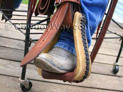 A stirrup leather hanging in front of a stirrup